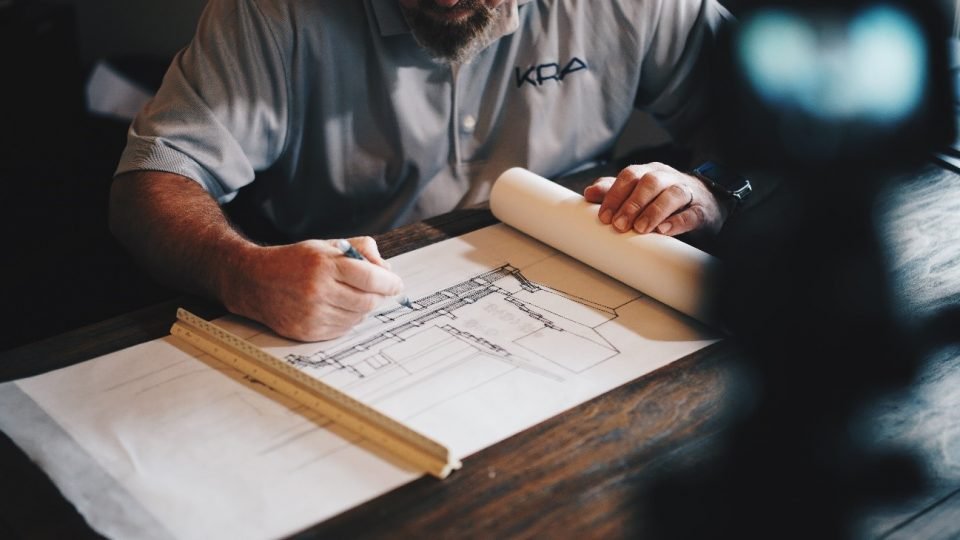 Arquiteto desenhando sobre a mesa.