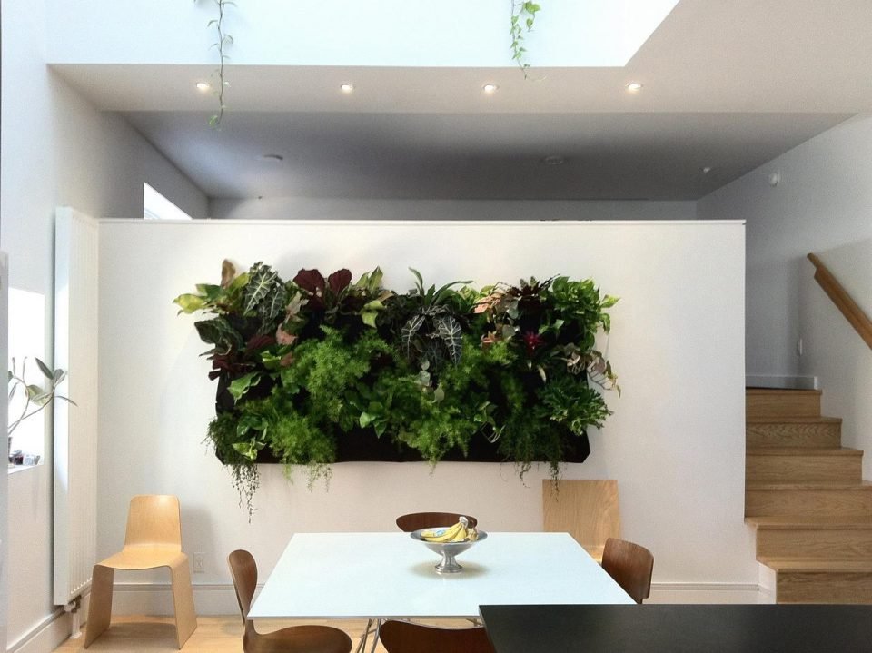 Jardim vertical em sala de jantar como divisória de ambientes.